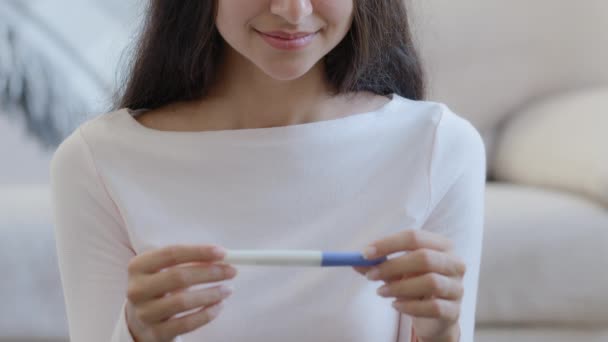 Unrecognizable young pregnant girl happy mom fertility woman expecting newborn child hold positive pregnancy test with two lines result of feminine hormones planning parenthood anticipate maternity - Filmagem, Vídeo