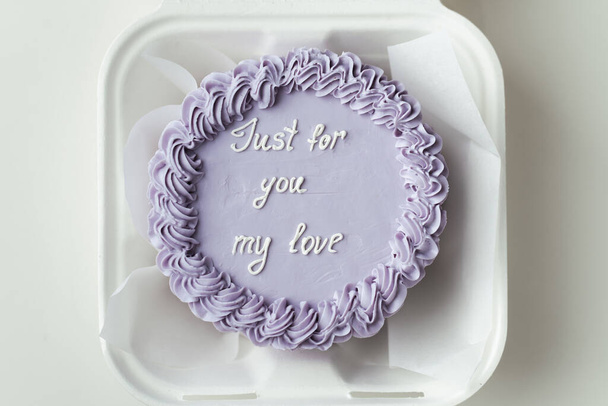 Small bento cake with velvet cream cheese frosting as a gift for St.Valentines day. Confession in love written on a cake. Trendy Korean dessert in a gift box on the white background - Photo, image