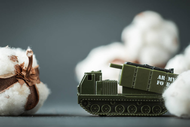 Model toy of Multiple Launch Rocket System or MLRS firing cotton flowers. Trendy Ukrainian banter about russian propaganda. Peace and no war concept. Macro shot. Bavovna is cotton in Ukrainian. - Photo, image