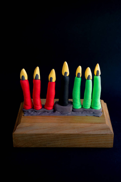 Kinara. Traditional Kwanzaa symbols. Isolated on black background. African American holiday. Hand-sculpted kinara from plasticine - Foto, Imagem