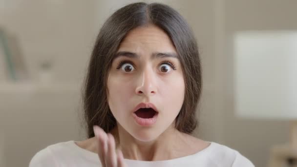 Afraid emotional girl brunette woman negative shocked frightened arabian young lady hold head with hands open mouth feel horror terrified facial emotion looking at camera panic confusion bad reaction - Video, Çekim
