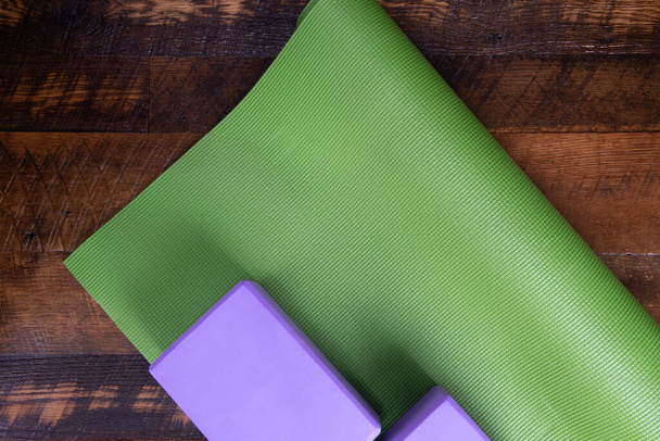 Yoga mat and blocks on a wooden floor.  Copy space. - Photo, Image