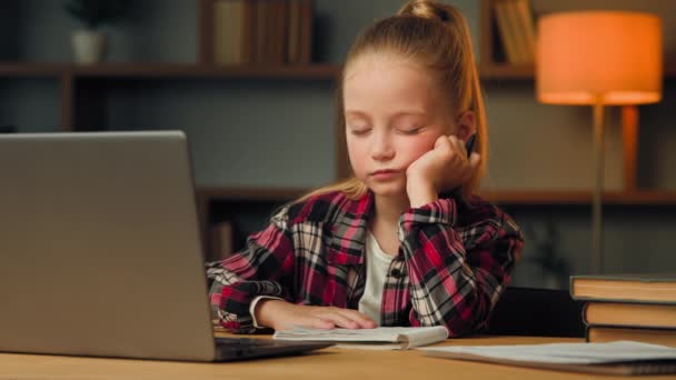 Weary sleepy caucasian young child blonde little lazy tired girl studying routine online elementary educational lesson on laptop napping at home feeling boredom chronic burnout fatigue after computer - 映像、動画