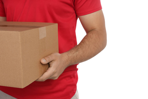 Courier holding cardboard box on white background, closeup - Fotó, kép