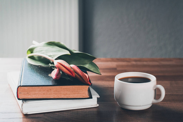 Libros y café en la mesa. Ramo de flores tulipanes. Buenos días. - Foto, Imagen
