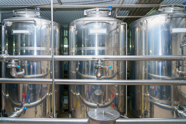 A stainless steel vat in the food industry at a brewery in the process of brewing beer. Background with selective focus and copy space for text - Photo, Image