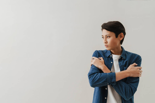 Asian boy wearing shirt posing and looking aside isolated over white background - Foto, Imagen