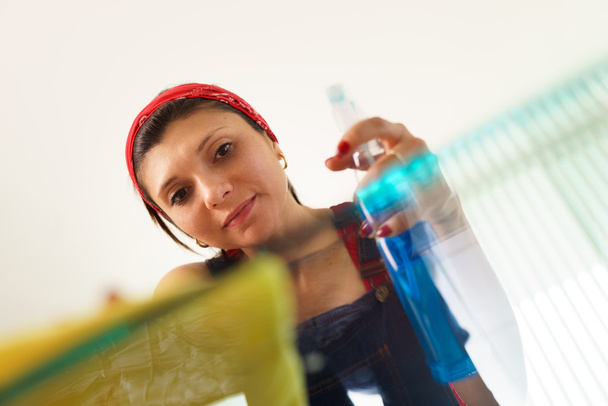 Hispán lány lány: otthon csinál házimunkát, tisztító üveg asztal - Fotó, kép