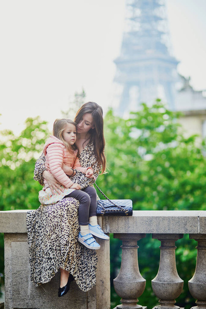 Happy family of two enjoying their trip to Paris, France. Mother and daughter near the Eiffel tower in Paris - Zdjęcie, obraz