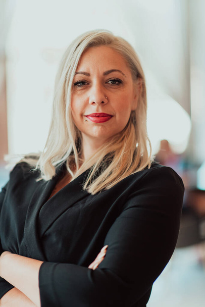 Portrait of a business senior woman with crossed arms standing in a modern corporation. Selective focus. High quality photo - Φωτογραφία, εικόνα