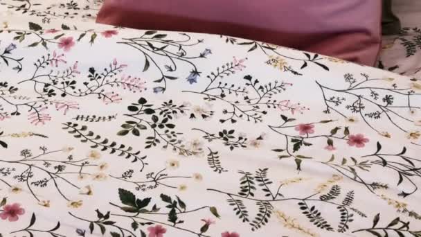 Vintage countryside style bedding with floral pattern on wooden bed in bedroom, interior design detail - Video