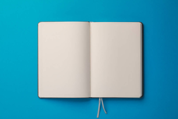 Blank notebook on light blue background, top view - Foto, afbeelding