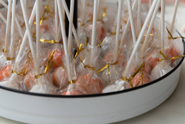 White chocolate covered cake pops are individually wrapped for party guests to take and a gift. - Фото, изображение