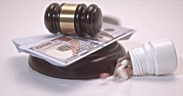 Pills and can of pills falling on a judges gavel on a white background. Concept For Medical Negligence, Bail, Monetary Compensation, Drugs Falsification - Séquence, vidéo
