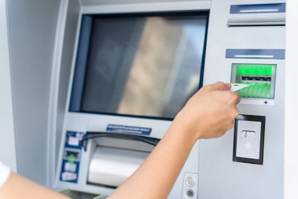 ATM ekranı. Amerikan banknotlarını elinde tutuyor. Kadın, 100 dolar çekmiş. Para yığını, banka kartı. - Fotoğraf, Görsel