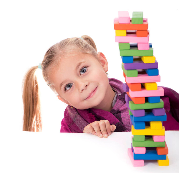 little girl playing with the wood game jenga on white background - 写真・画像