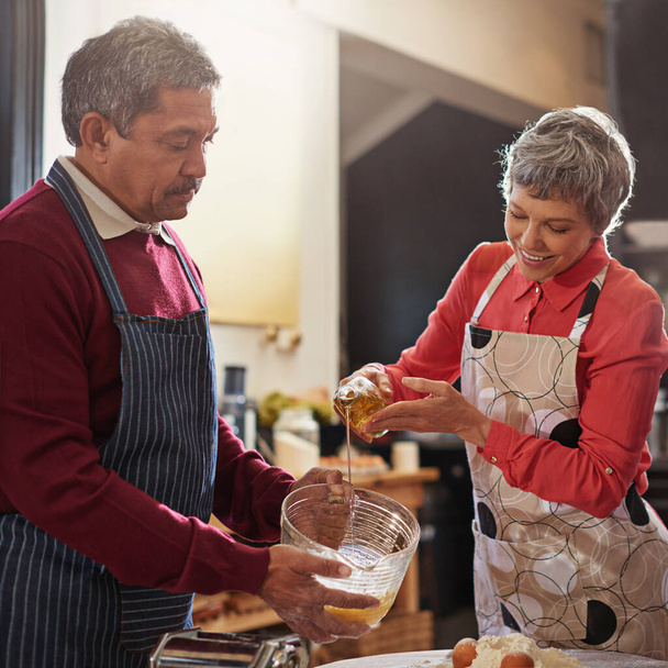 Our favorite thing to do at home iscook. a senior couple baking in the kitchen - Zdjęcie, obraz