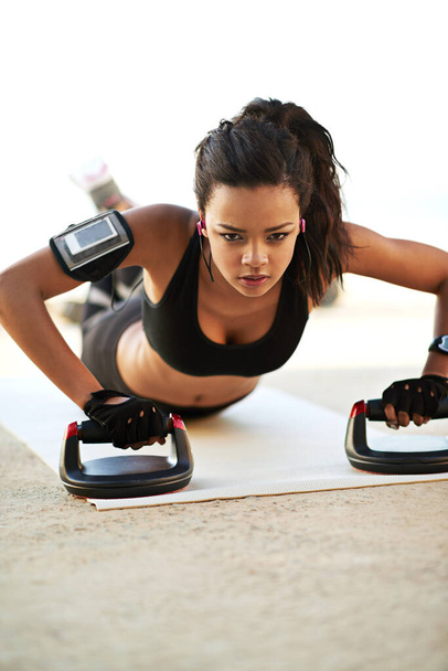 The ultimate upper body workout. a young woman exercising using push up grips - Φωτογραφία, εικόνα