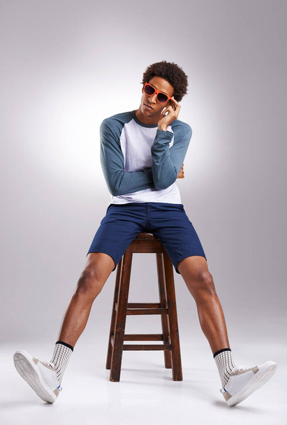 People will stare, make it worth their while. Studio shot of a fashionable young man sitting on a stool - Foto, Imagem