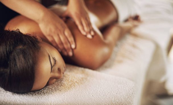 No such thing as too much pampering. High angle shot of a young woman getting a massage at the spa - Foto, Imagen
