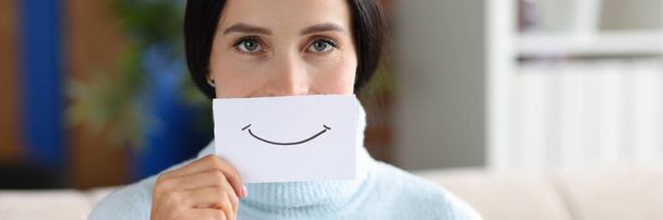 Femme tient un bout de papier avec le sourire. Concept d'humeur et d'émotions positives - Photo, image