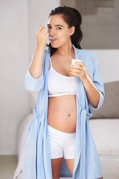 Dairy goodness for a growing baby. a pregnant woman enjoying a snack at home - Foto, afbeelding
