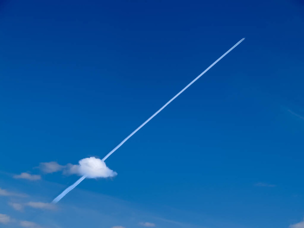 Small jets in distance create diagonal chem-trails across blue sky through small puffy lower cloud in Yukon sky. - Photo, Image