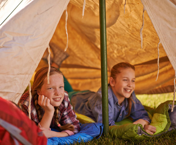 Completely content in their tent. two young girls relaxing in their tent on a camping trip - Zdjęcie, obraz