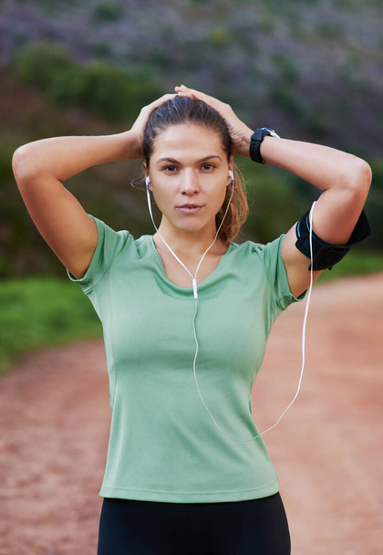 Music on...now Im ready to run. a young woman listening to music while out running - Valokuva, kuva