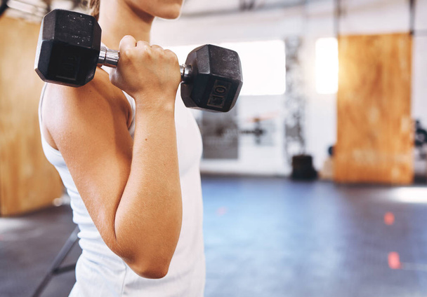 Training, health and weightlifting by woman exercise with a dumbbell at gym or fitness center. Young athlete join on gym membership, begin physical health journey, muscle, physical and body goals. - 写真・画像