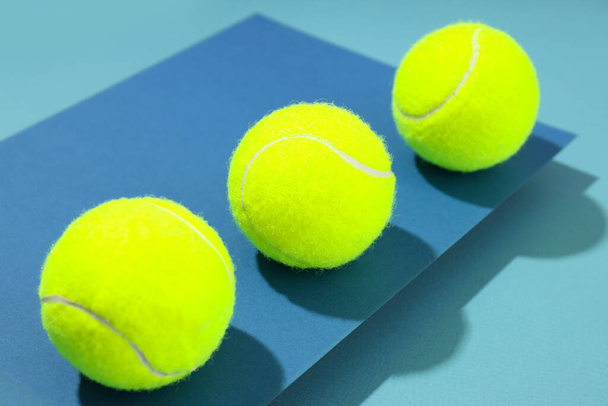 Tennis balls on two tone blue background - Foto, afbeelding