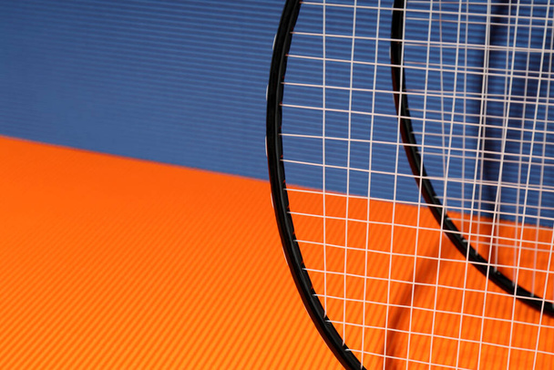 Badminton rackets on orange and blue textured backgrounds - Fotó, kép