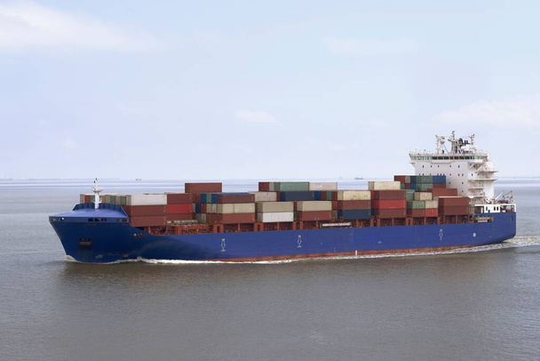 Small container vessel with a blue hull underway on Elbe river - Photo, Image