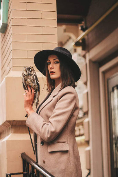 very beautiful girl in a hat with an owl. High quality photo - Φωτογραφία, εικόνα
