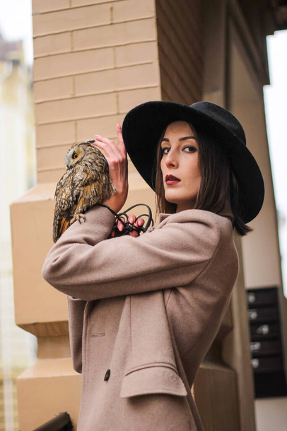 very beautiful girl in a hat with an owl. High quality photo - Foto, Imagem