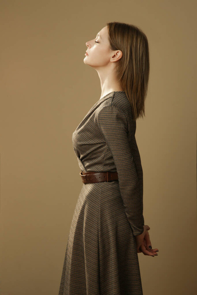 Serie of studio photos of young female model in brown tweed dress, autumn winter fashion collection. - Photo, Image