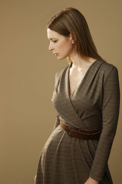 Serie of studio photos of young female model in brown tweed dress, autumn winter fashion collection. - Photo, Image