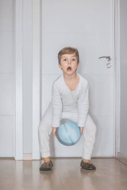 Kid having fun in the morning and playing with a ball at home.  - Fotografie, Obrázek
