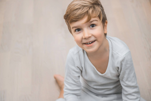Portrait of happy kid sitting on the floor and looking at camera.  - Φωτογραφία, εικόνα