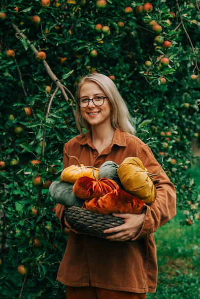 Woman in brown shirt hold handmade fabric pumpkins as decoration for Halloween holiday - Foto, Bild