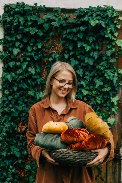 Woman in brown shirt hold handmade fabric pumpkins as decoration for Halloween holiday - Foto, immagini