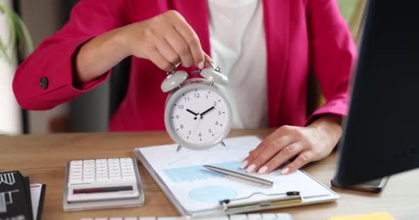 Business woman holding alarm clock at workplace. Time management of personal efficiency and work time planning - Filmagem, Vídeo