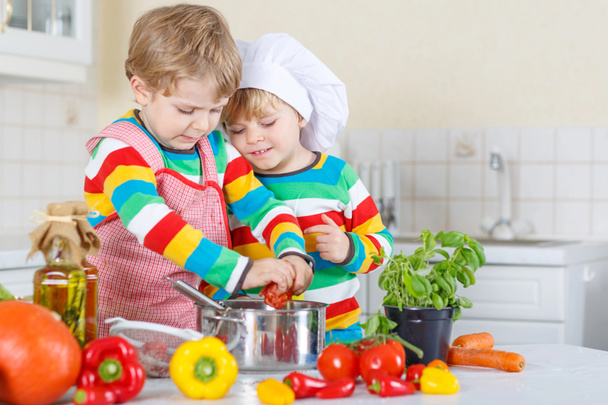 Two cute little kid boys cooking italian soup and meal with fres - Foto, Bild