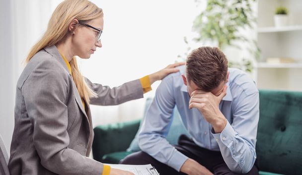 Mature blond woman psychologist helps stressed man, talk about motivation, health care concept - Photo, image