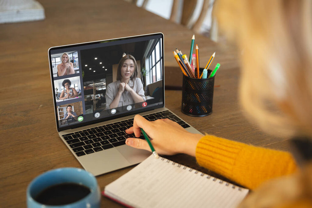 Composition of caucasian businesswoman having video call with colleagues in office. Global business and digital interface concept digitally generated image. - Фото, изображение