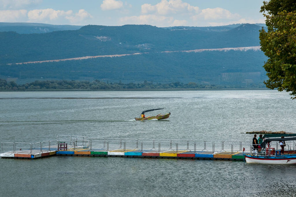 O cais na margem do Lago Apolyont e o barco de turismo no lago. Barco de Foco Seletivo. Uluabat, Glyaz, Bursa, Turquia. - Foto, Imagem