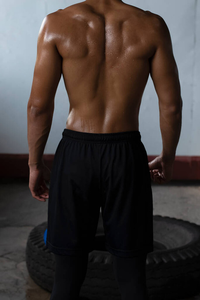 Back side of young man,showing Fit and firm muscle from exercise,drenched in sweat,wet all over body. - Foto, immagini
