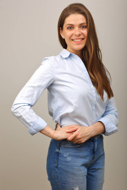 Smiling woman in blue shirt keeps her arms on hip. isolated portrait. - Zdjęcie, obraz