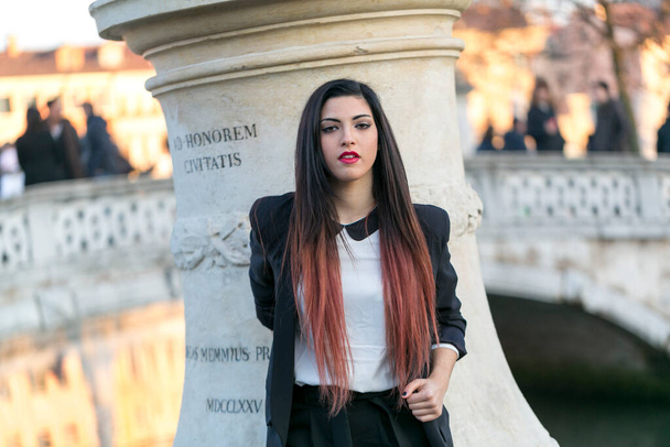 beautiful brunette girl standing in front of marble column. High quality photo - Zdjęcie, obraz