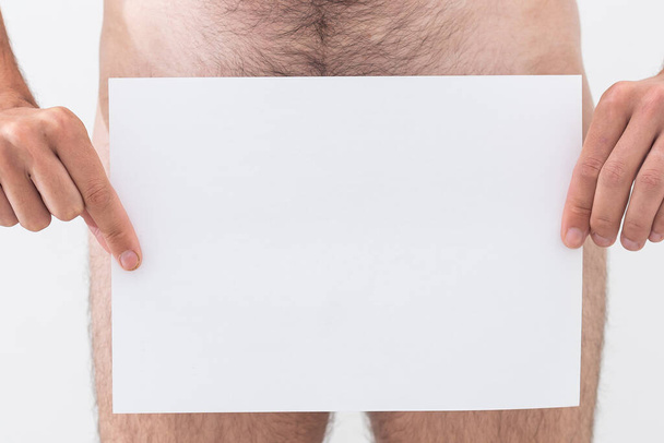 Naked guy with poster template, man holding paper. - Zdjęcie, obraz